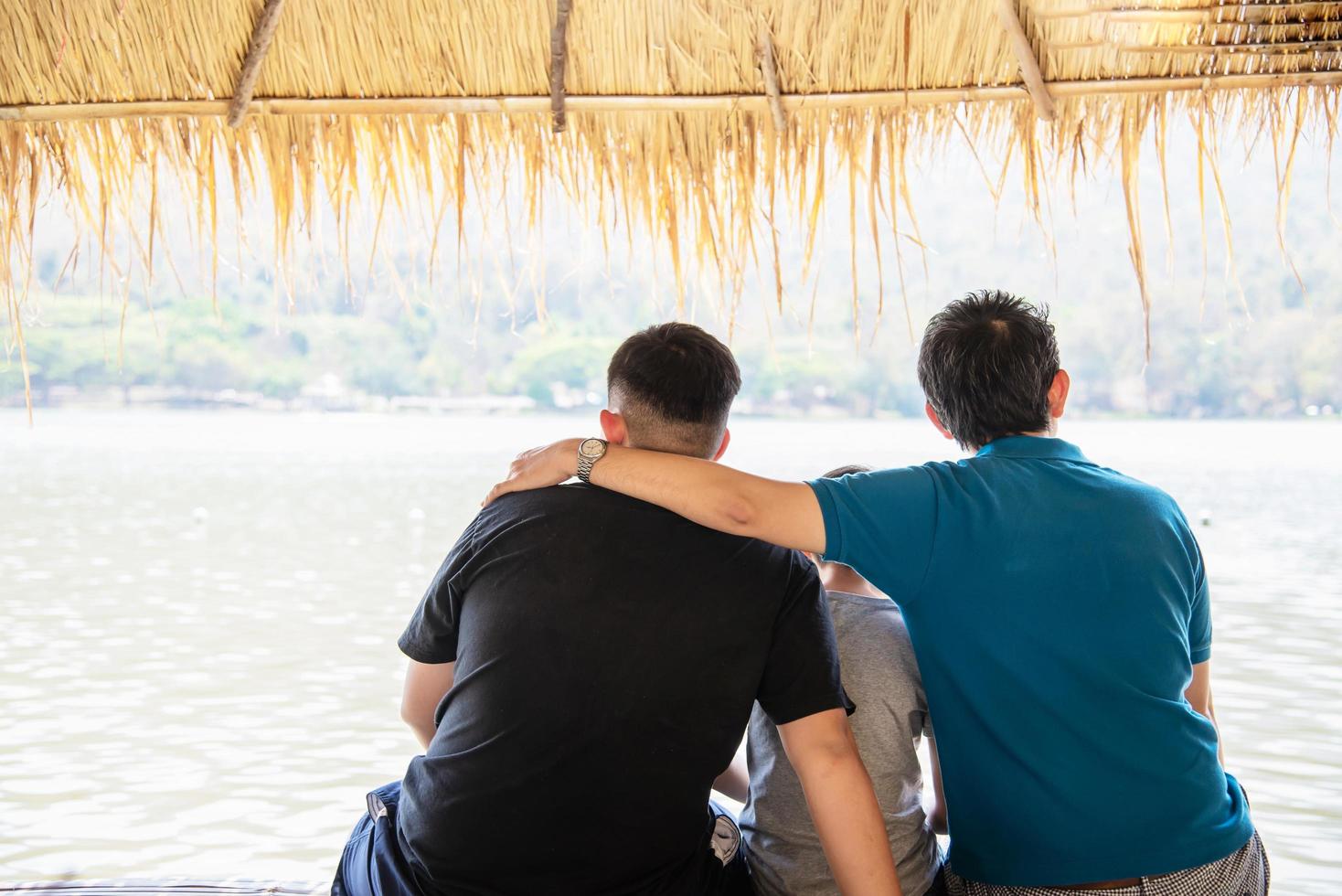 glücklicher vater und sohn während des urlaubs am wasserstandort natur - glückliches familienurlaubskonzept foto