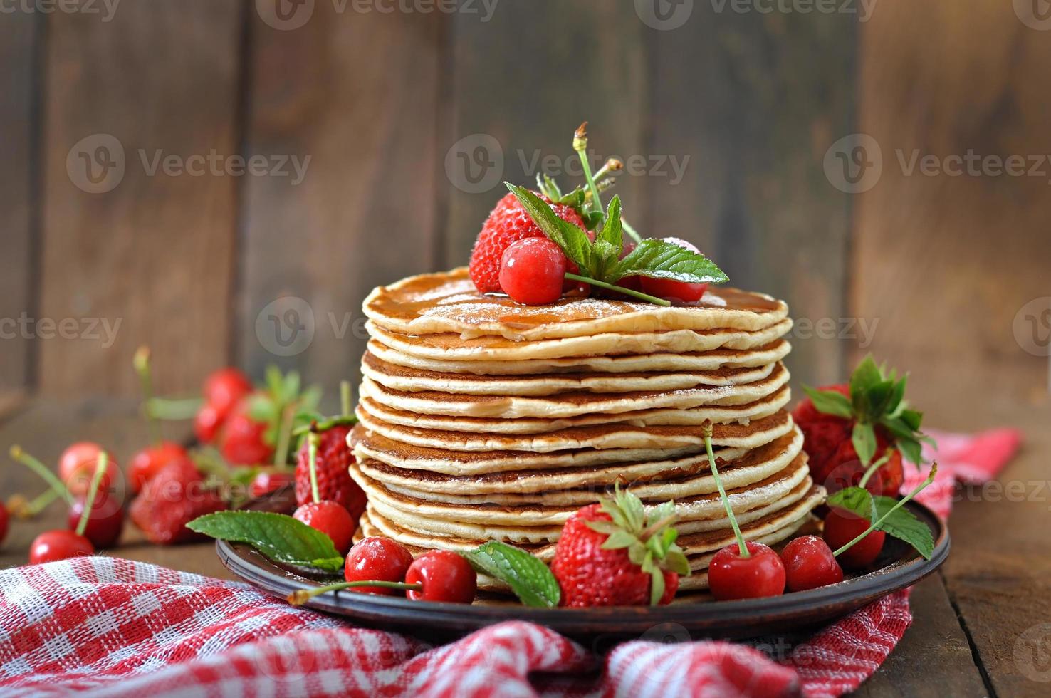 Pfannkuchen mit Beeren und Sirup im rustikalen Stil foto