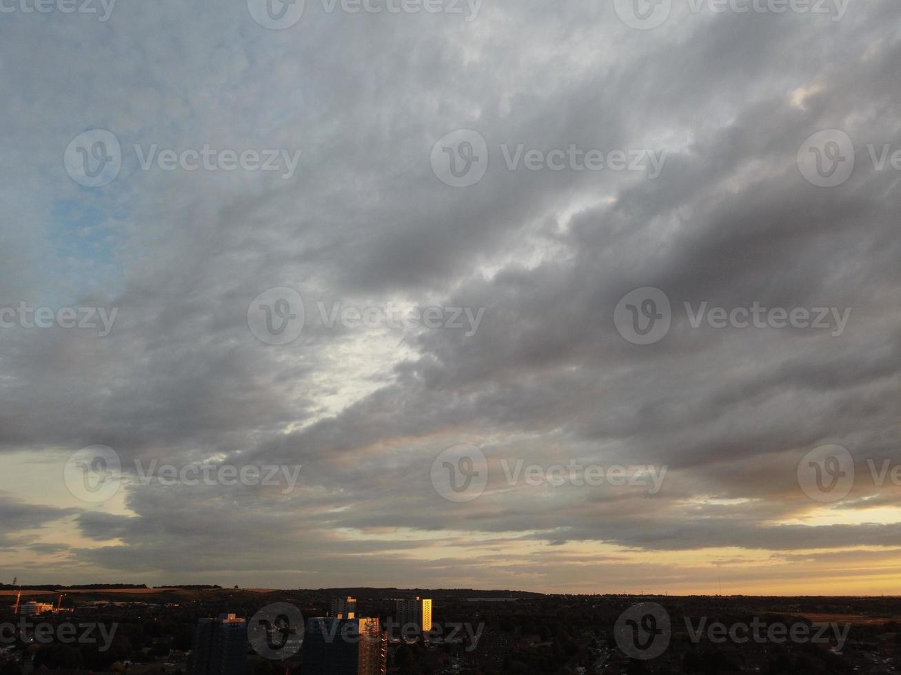 schöner sonnenuntergang über der britischen stadt, bunter himmel mit gelben, orangefarbenen und schwarzen wolken über hellblauem himmel foto