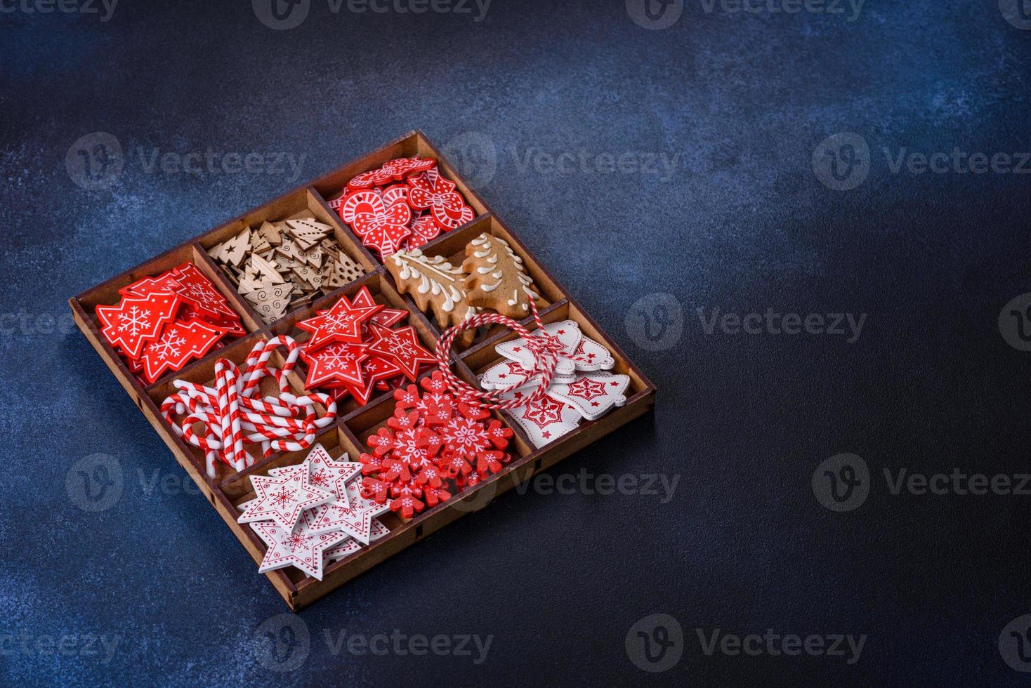 weihnachtsspielzeug in weiß und rot in einer holzbox vor dunklem betonhintergrund foto