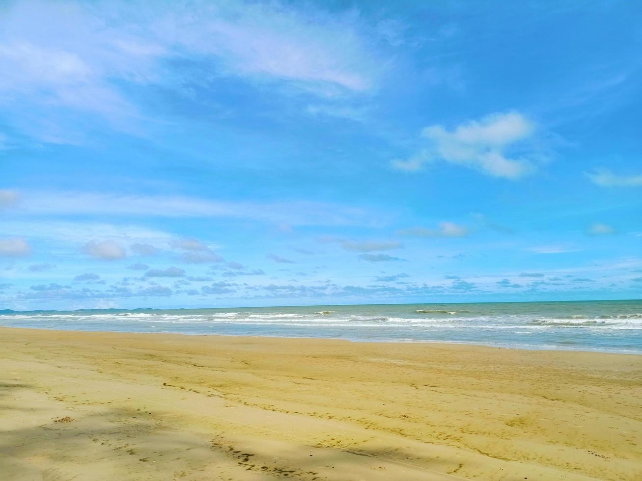 strandsand und blauer himmel. gelber warmer sand und sommermeer mit himmel und freiraum. foto