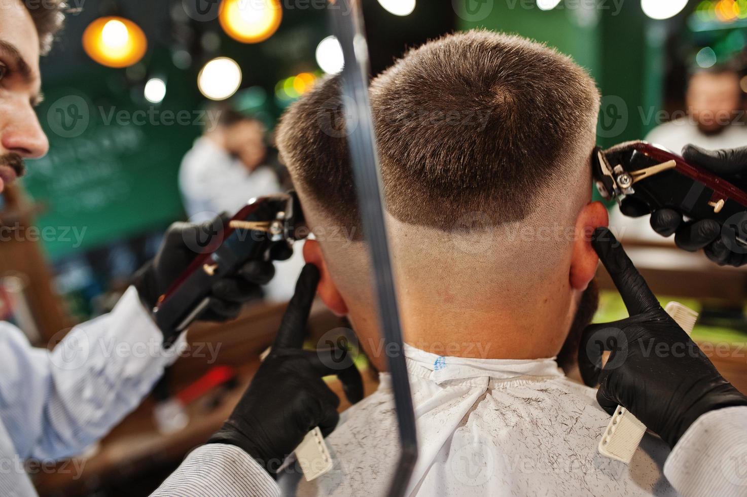 hübscher bärtiger mann im friseursalon, friseur bei der arbeit. Nacken schließen. foto