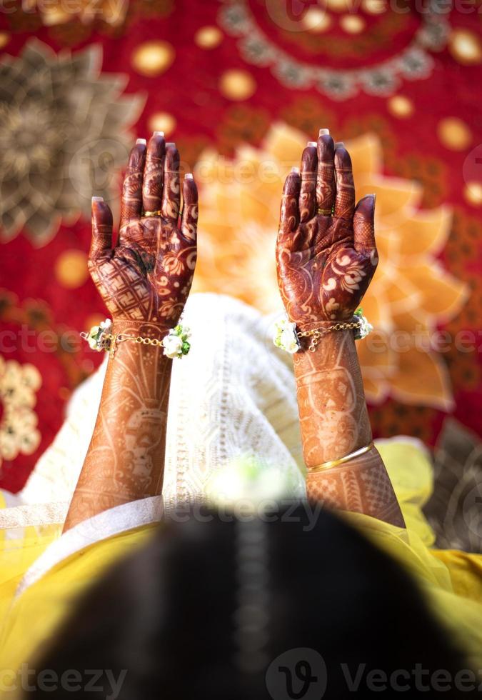 schöne indische braut, die hände mehndi design zeigt. paar hände draufsicht auf das traditionelle henna-design auf der hand der braut. foto