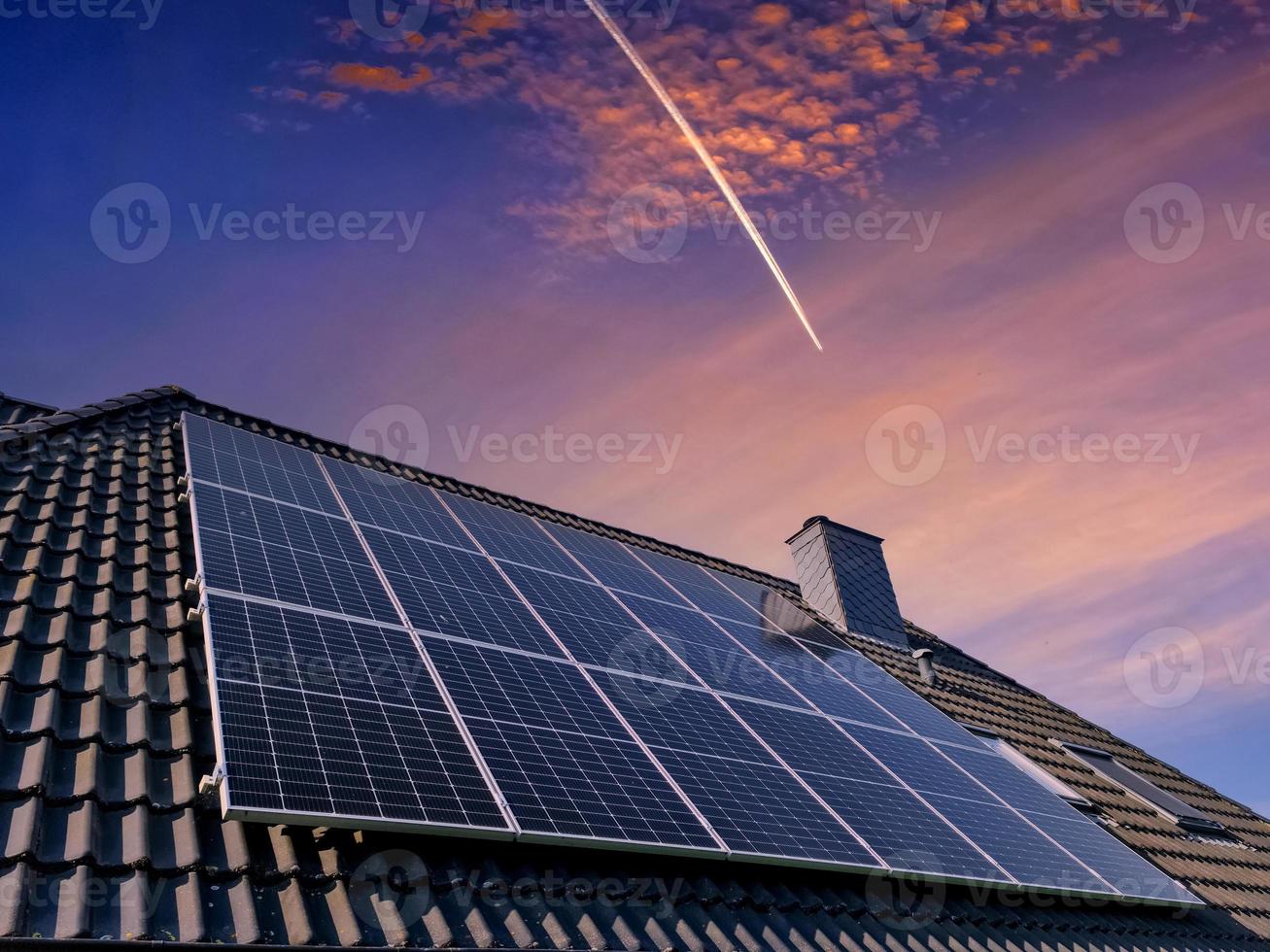 Sonnenkollektoren produzieren saubere Energie auf dem Dach eines Wohnhauses foto