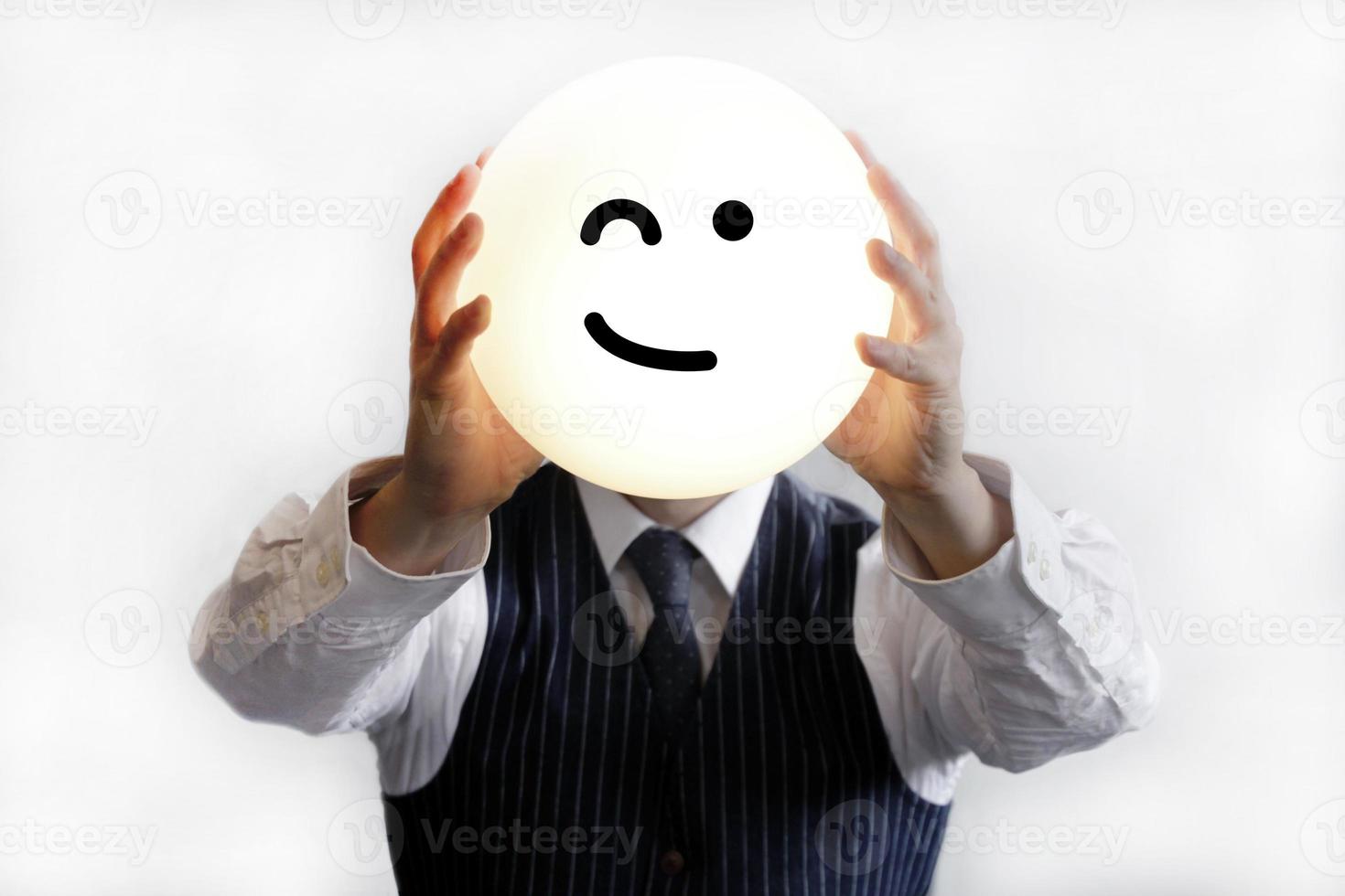 Geschäftsmann hält einen zwinkernden Smiley hoch foto