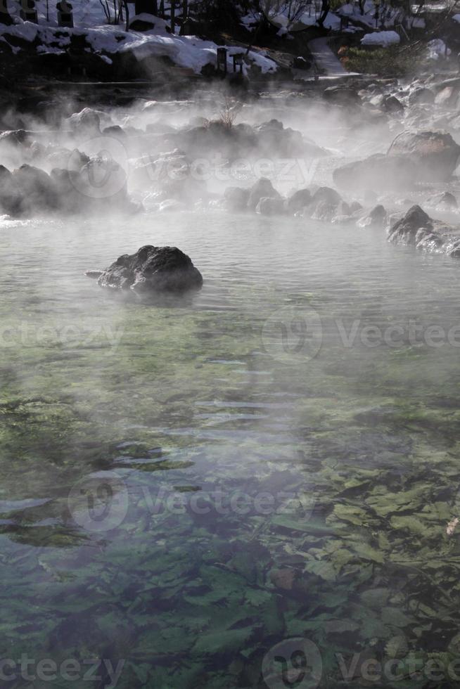 ein fluss mit heißem wasser fließt durch den wald bei kusatsu onsen, japan foto