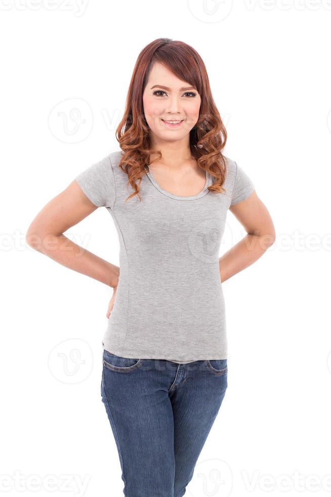 glückliche Teenagerin im leeren grauen T-Shirt auf weißem Hintergrund foto