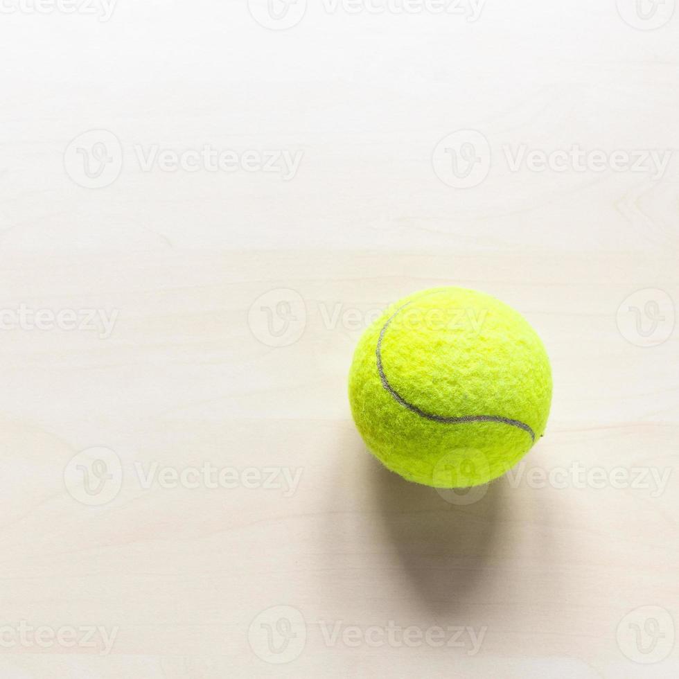 Tennisball auf hellbraunem Holztisch foto