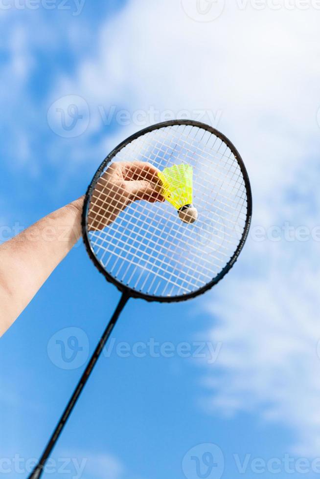 Hand schlägt Federball mit Badmintonschläger foto