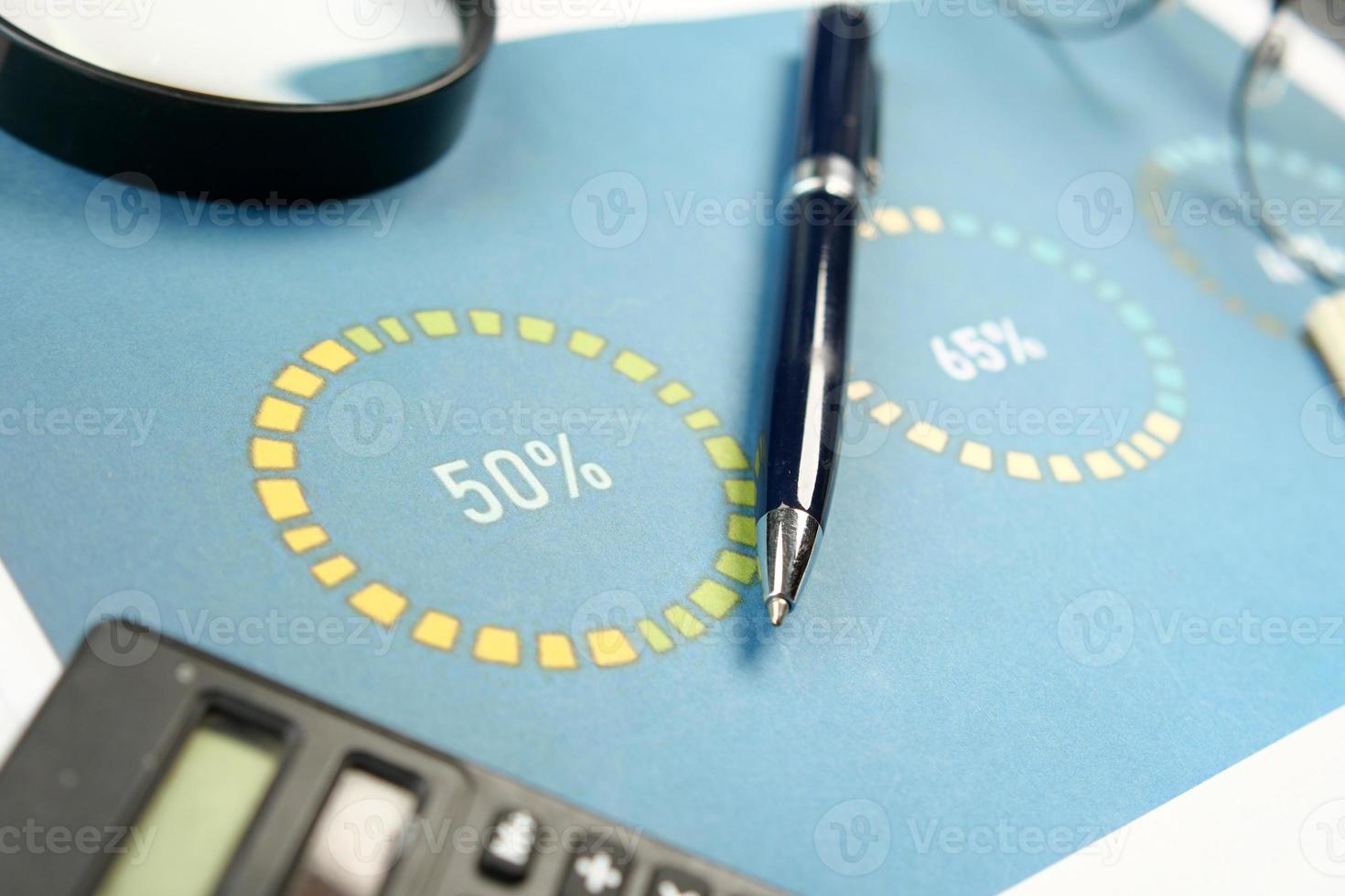 Finanzdiagramm, Taschenrechner und Notizblock auf dem Tisch foto