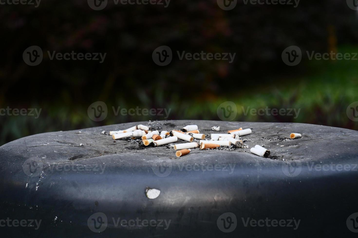 Brennende Zigarette im Aschenbecher auf dem Abfalleimer hautnah foto