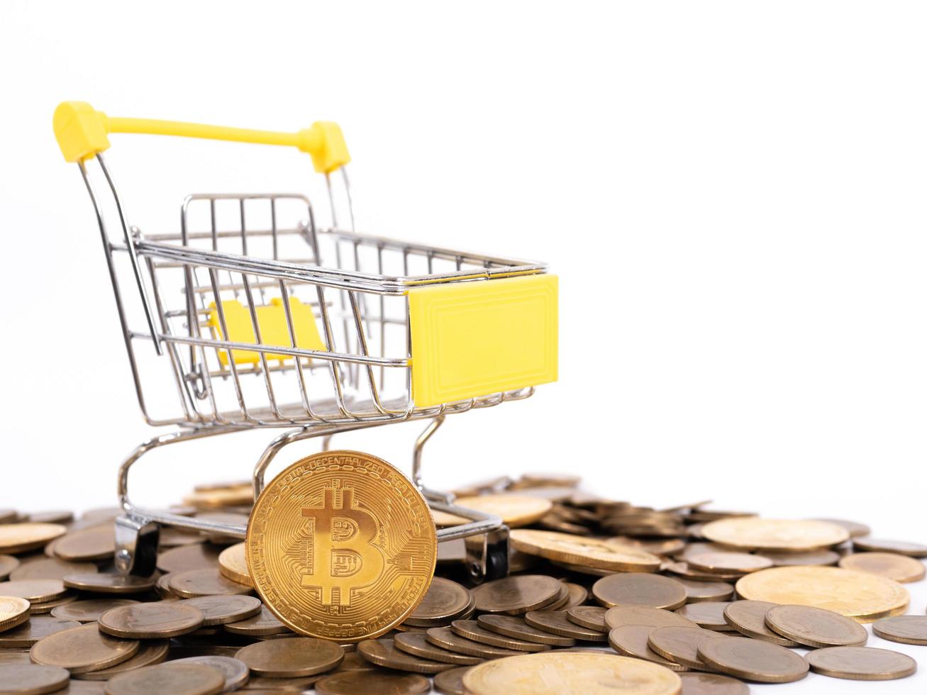 Kryptowährung bezahlen Der Einkaufswagen im Supermarkt ist mit Goldmünzen von Bitcoin auf weißem Hintergrund gefüllt. Platz kopieren foto