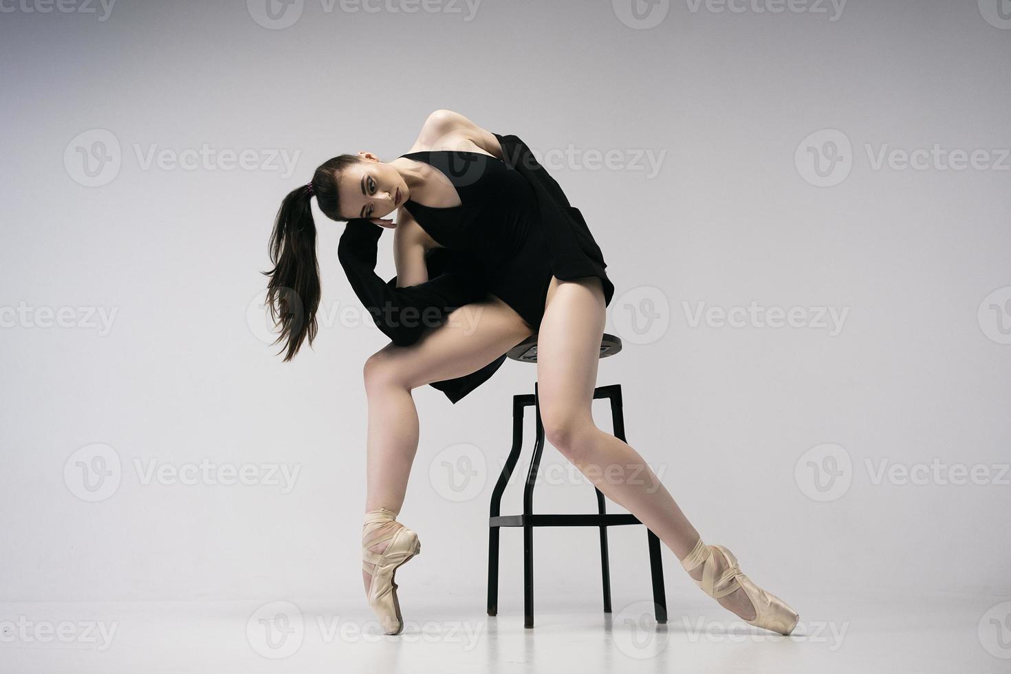 ballerina in einem body und einer schwarzen jacke improvisiert klassische und moderne choreographien in einem fotostudio foto