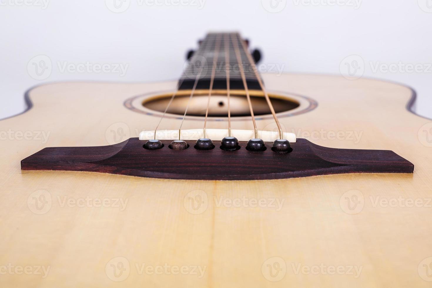 Holzstruktur des Unterdecks der sechssaitigen Akustikgitarre auf weißem Hintergrund. Gitarrenform foto