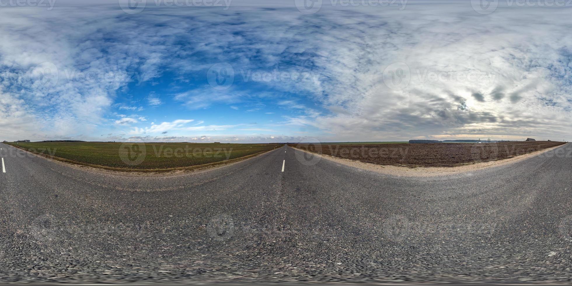 volles kugelförmiges nahtloses Panorama 360-Grad-Winkelansicht auf verkehrsfreier Asphaltstraße zwischen Feldern an sonnigen Tagen mit bewölktem Himmel. 360-Grad-Panorama in äquirektangularer Projektion, VR-Inhalt foto