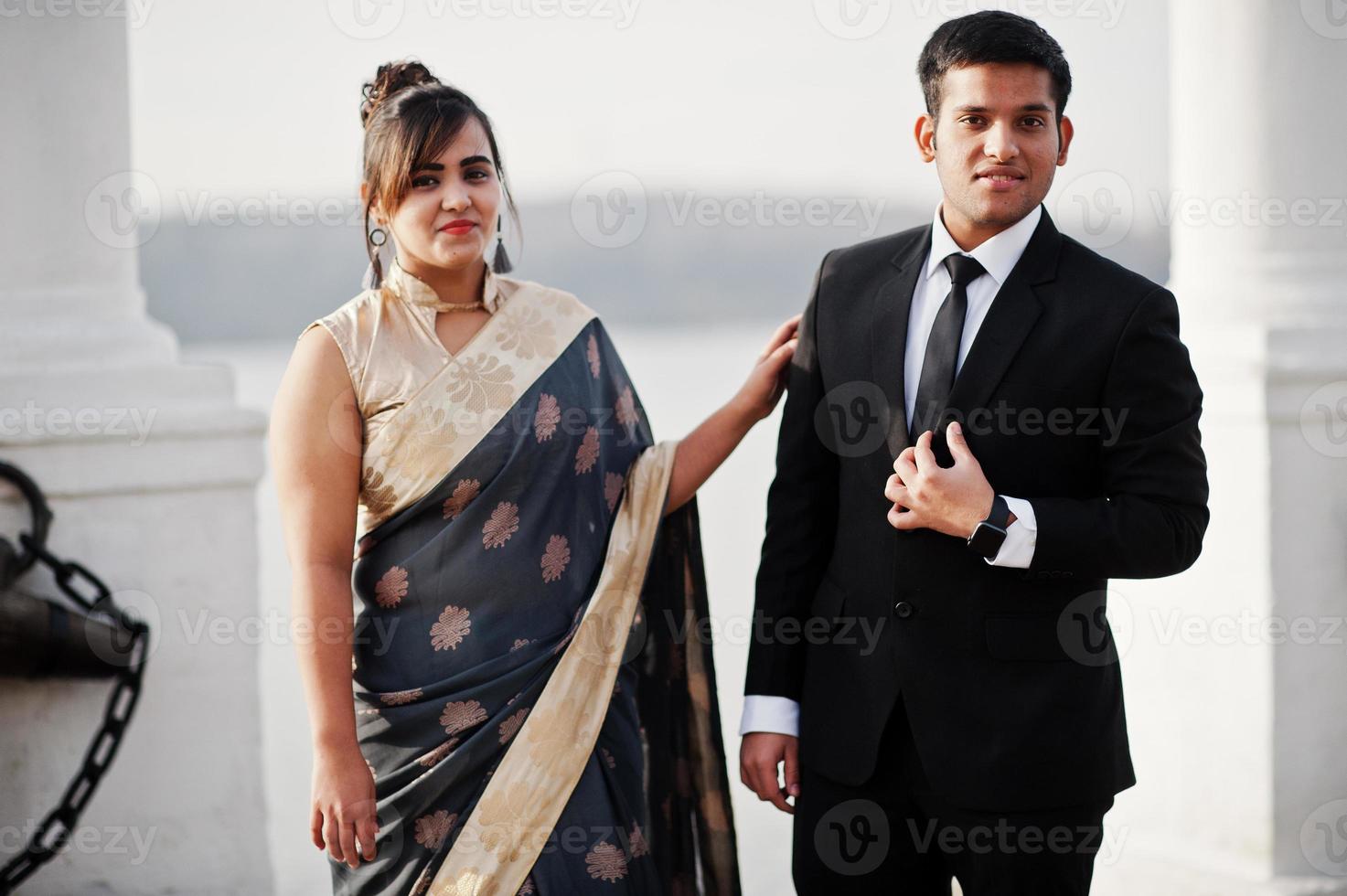 elegante und modische indische freunde paar frau im saree und mann im anzug posierten am ufer des marinas. foto