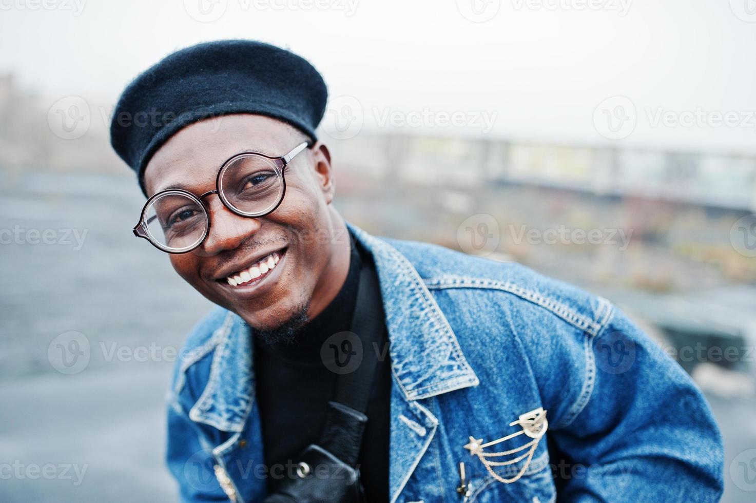 Nahaufnahme Porträt eines afroamerikanischen Mannes in Jeansjacke, Baskenmütze und Brille. foto