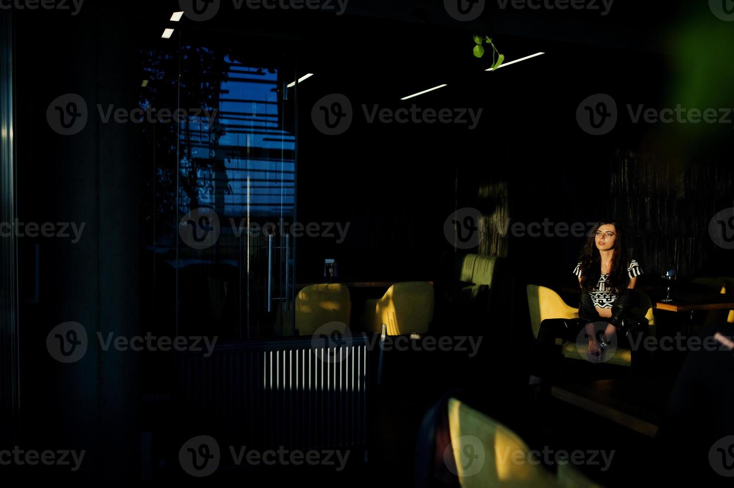 junge lockige Frau in Lederjacke in einer Bar. foto