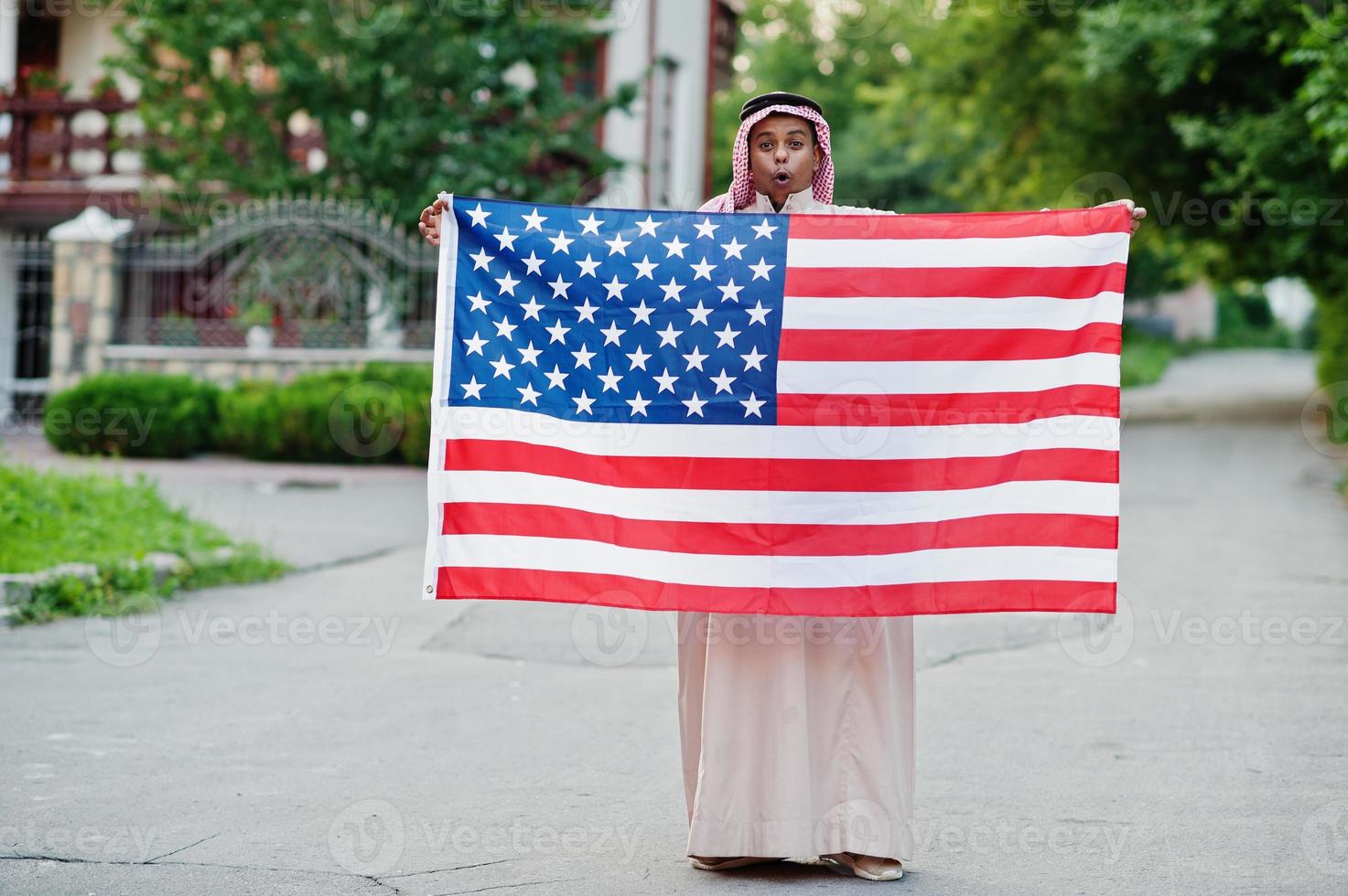 Nahöstlicher arabischer Mann posierte auf der Straße mit usa-Flagge. konzept für amerika und arabische länder. foto