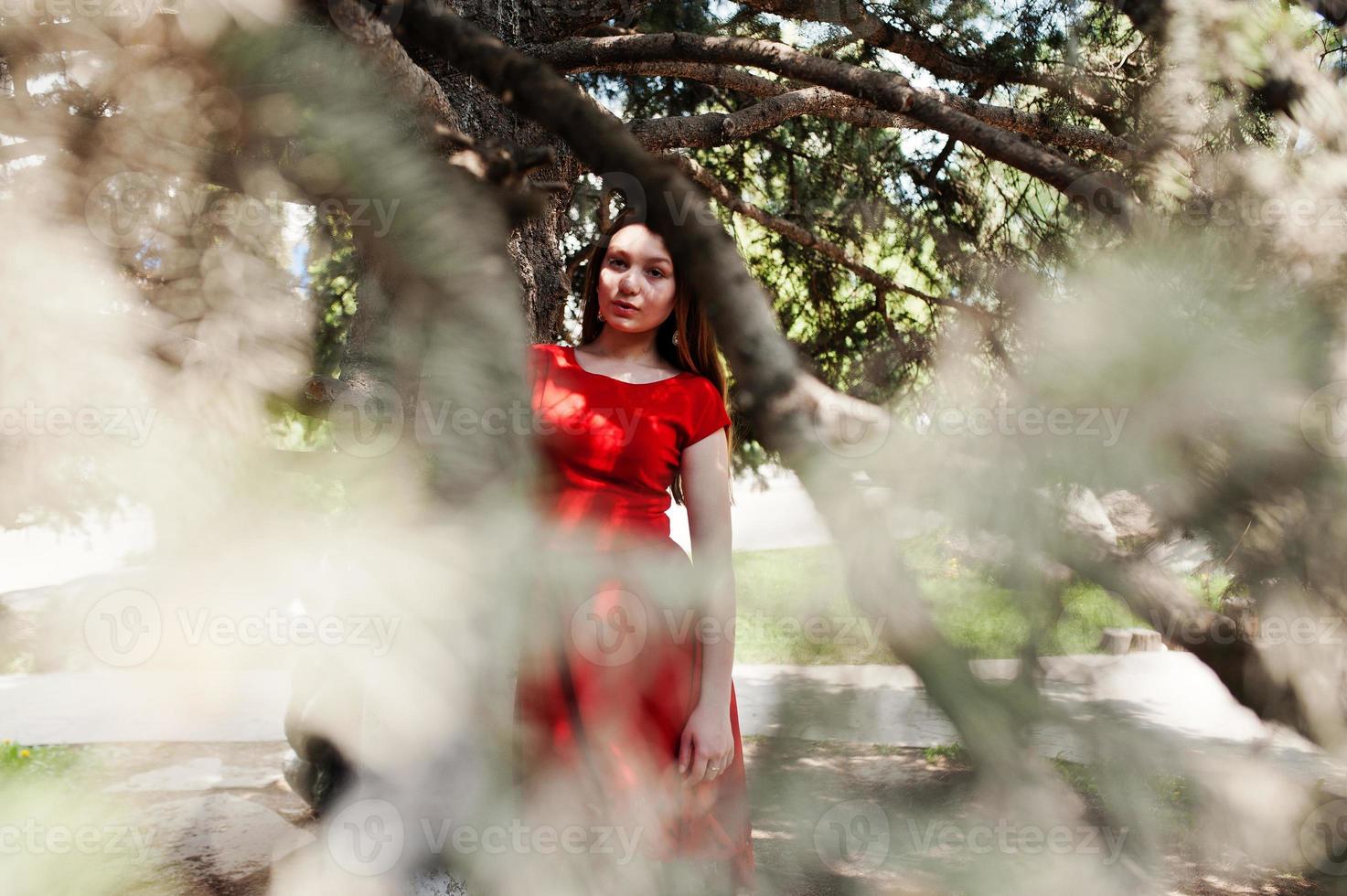 Teenager-Mädchen im roten Kleid posierte im Freien an einem sonnigen Tag. foto