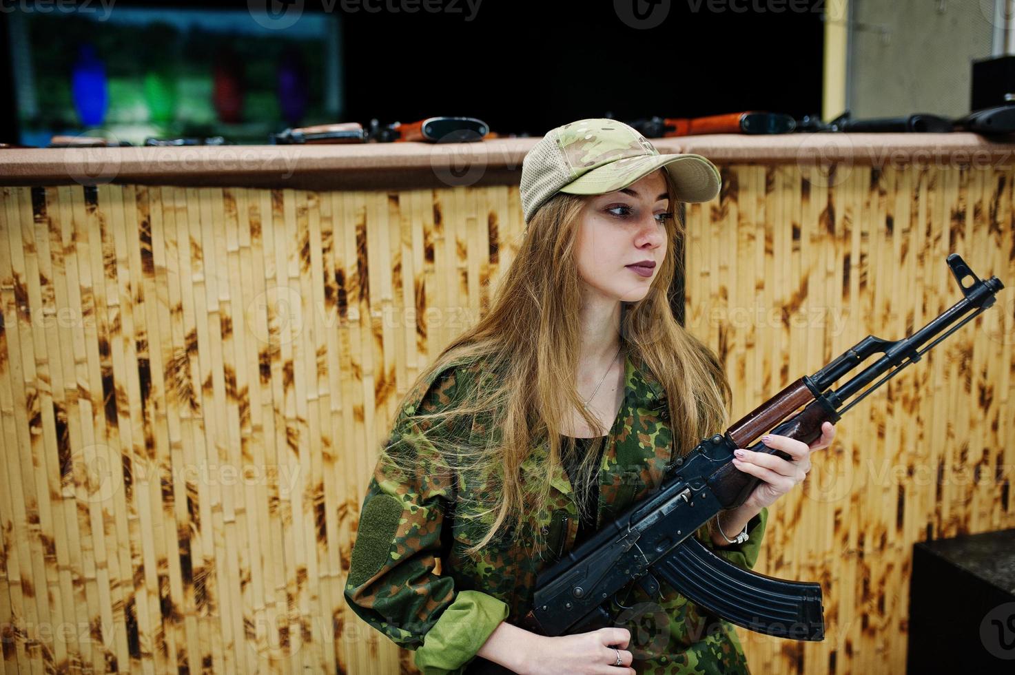 Mädchen mit Maschinengewehr an den Händen auf dem Schießstand. foto