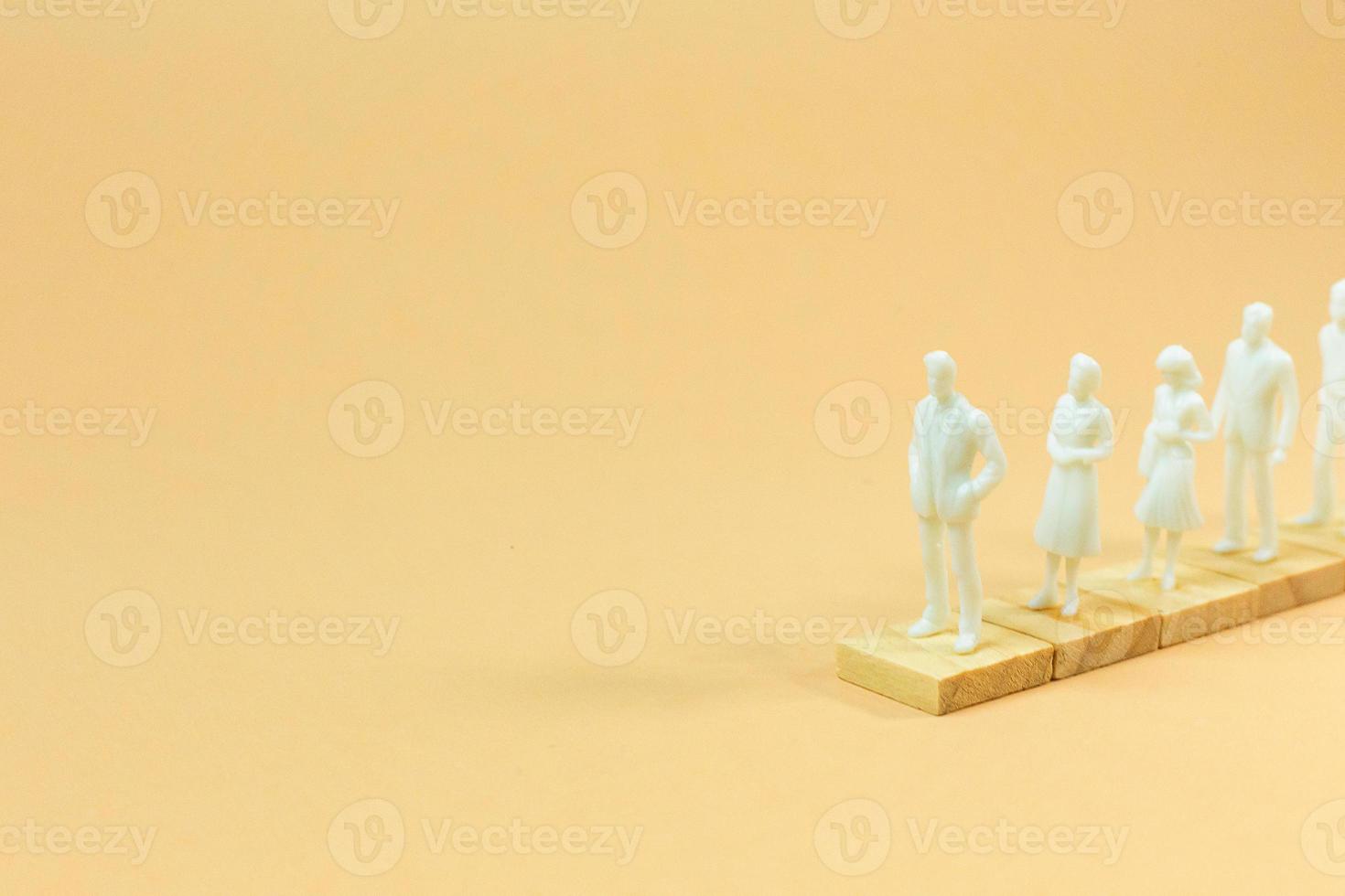 weiße Figurenminiatur auf orangefarbenem Pastell für geschäftliche Inhalte. foto