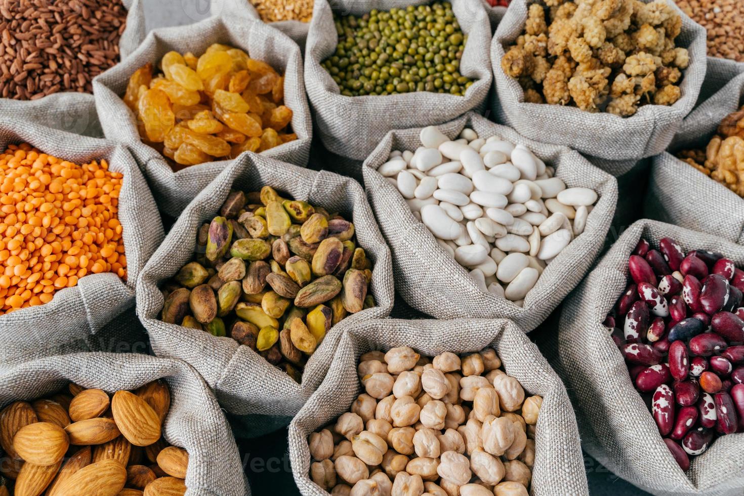 verschiedene Arten von Trockenfrüchten und Getreide auf dem Bauernmarkt. Mungobohnen, Mandeln, Maulbeeren, Kichererbsen, Rosinen. Nahaufnahme foto