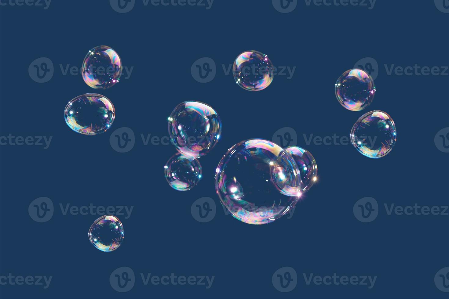 fliegende Seifenblasen isoliert auf blauem Hintergrund. abstrakter Hintergrund. foto