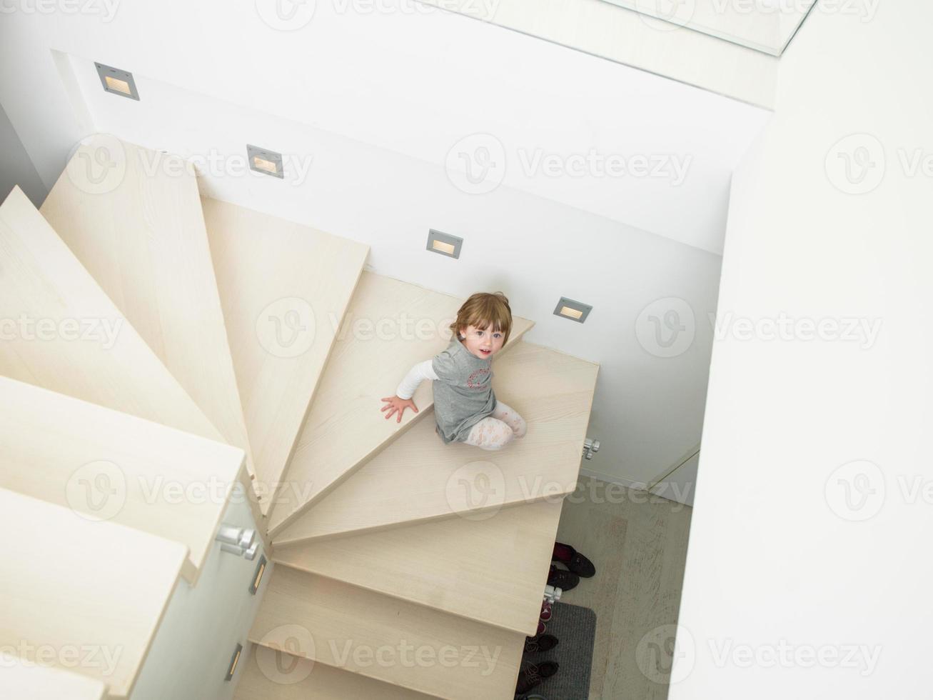 kleines süßes mädchen, das auf der treppe genießt foto