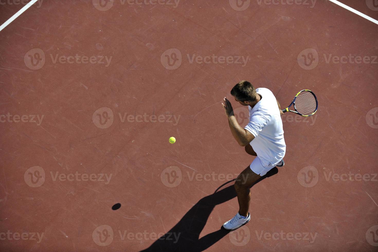 junger mann spielt tennis foto