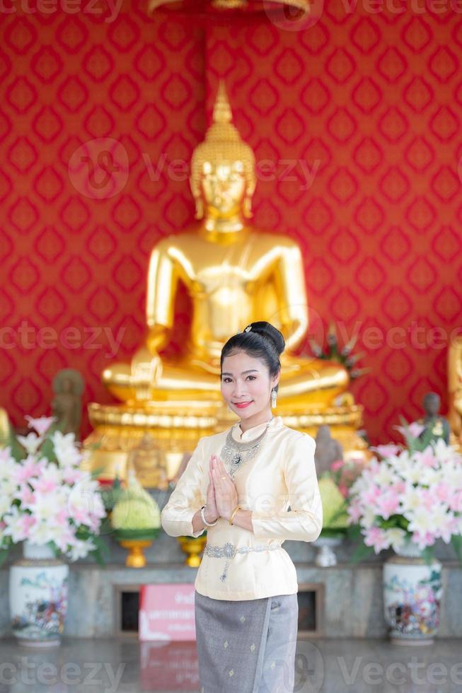 eine Frau, die thailändische Kleidung trägt, die das Sawasdee-Symbol ehrt. foto