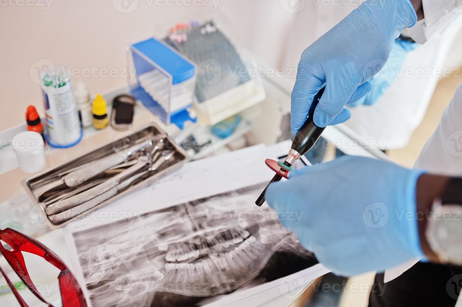 konzept für zahnarztpraxis und arztpraxis. schließen uo der hände professioneller afrikanisch-amerikanischer arzt in der zahnheilkunde medizinisch, der auf zähne röntgen zeigt. foto