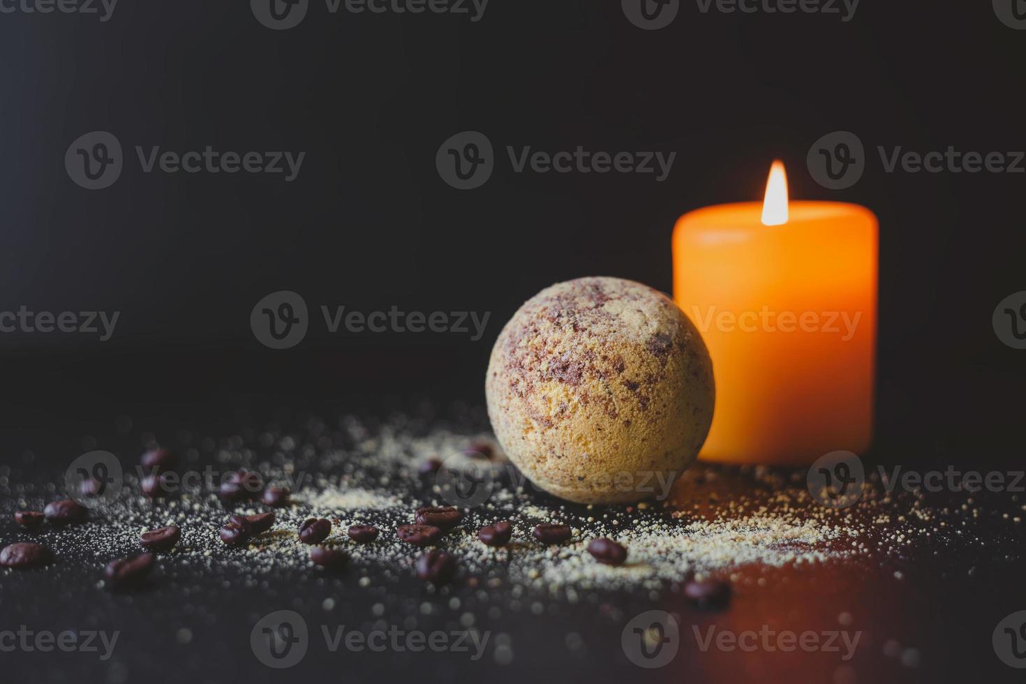 Badebombe und Kaffeebohnen und brennende Kerze auf dunklem Hintergrund. Spa-Konzept. foto