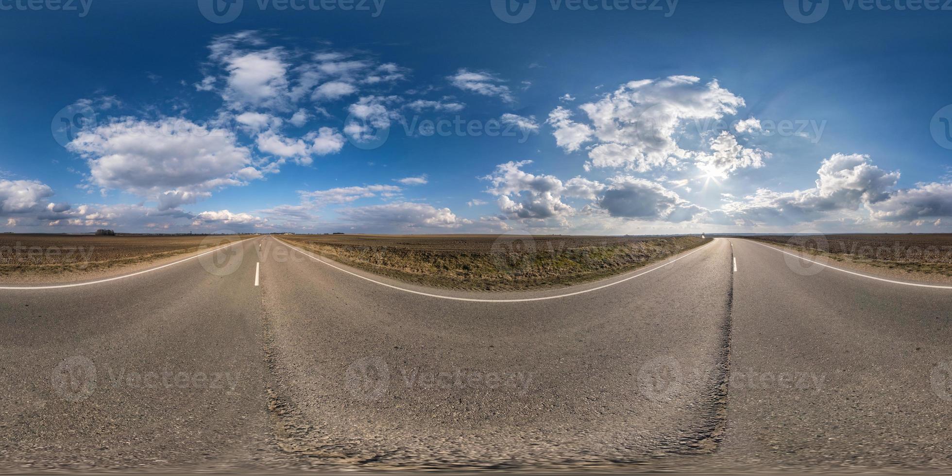 volles kugelförmiges nahtloses Panorama 360-Grad-Winkelansicht auf verkehrsfreier Asphaltstraße zwischen Feldern an sonnigen Tagen mit bewölktem Himmel. 360-Grad-Panorama in äquirektangularer Projektion, VR-Inhalt foto