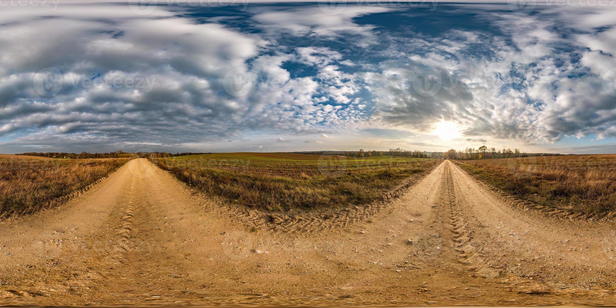 Vollständiges, nahtloses sphärisches HDRI-Panorama 360-Grad-Winkelansicht auf Schotterstraße zwischen Feldern am Herbsttag mit schönen Wolken in equirectangularer Projektion, bereit für VR-AR-Virtual-Reality-Inhalte foto