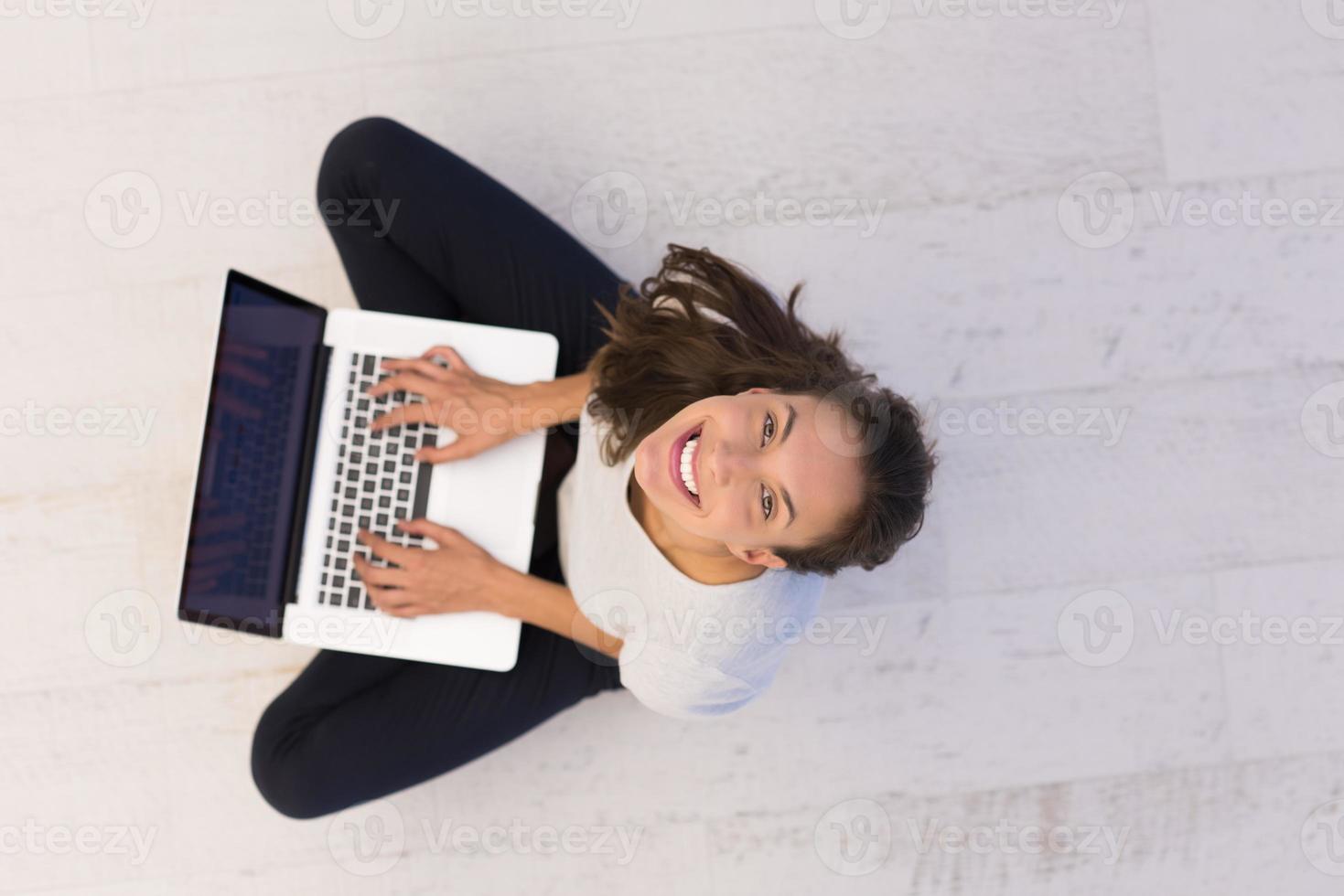 frauen, die laptop-computer auf der draufsicht des bodens verwenden foto