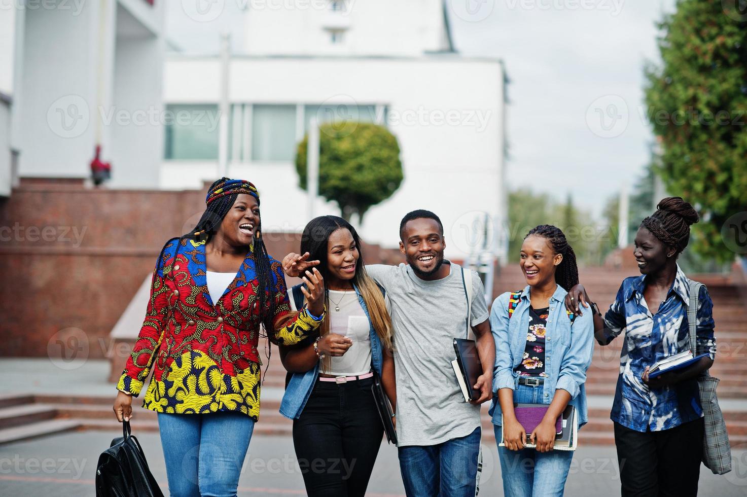 Gruppe von fünf afrikanischen College-Studenten, die gemeinsam Zeit auf dem Campus des Universitätshofs verbringen. Schwarze Afro-Freunde studieren. Thema Bildung. foto