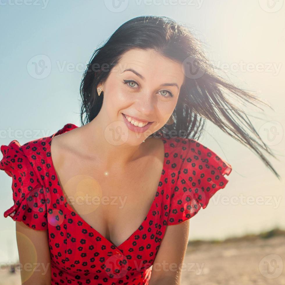 junges Mädchen im roten Kleid auf dem Meer foto