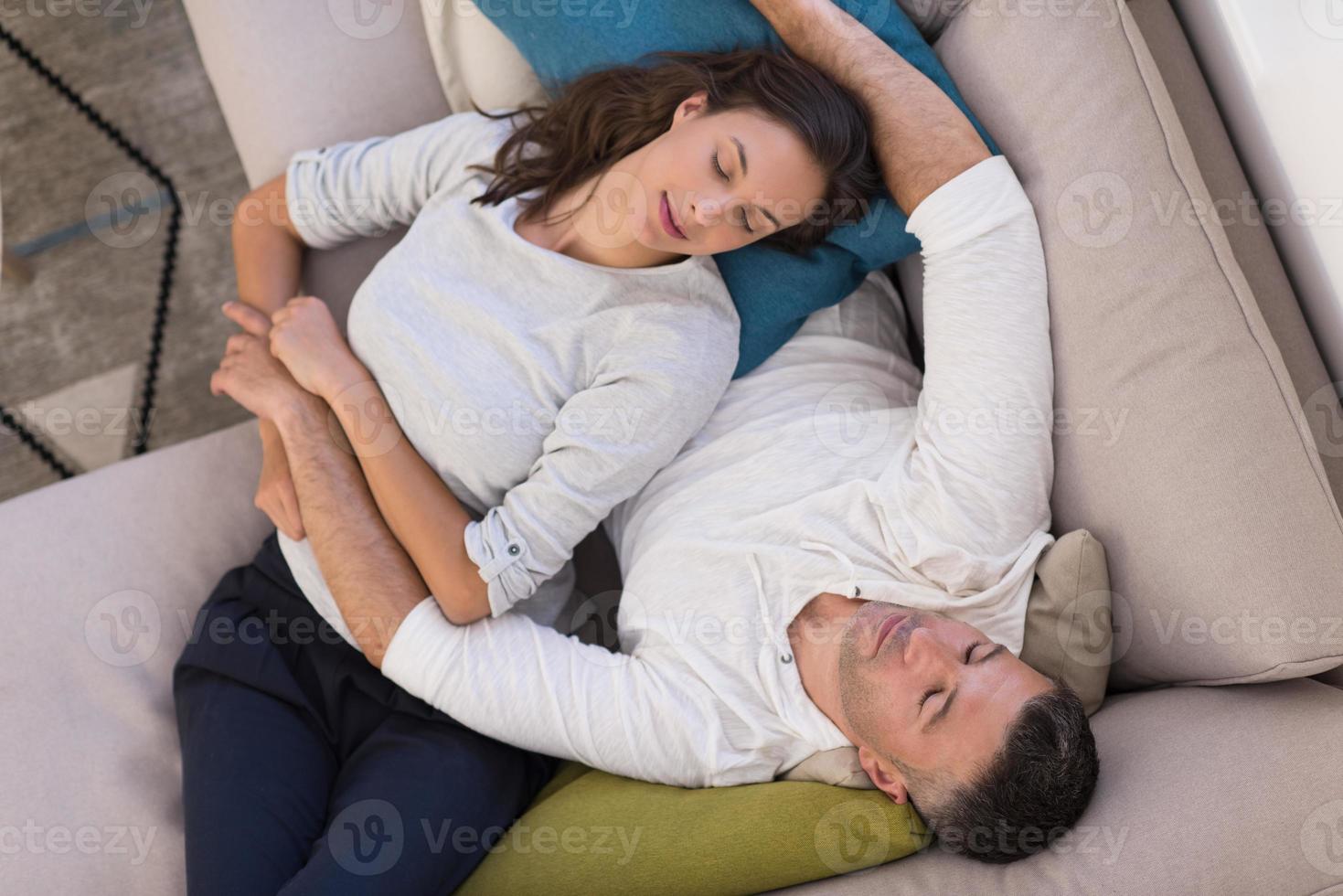 junges Paar auf dem Sofa vor dem Fernseher Draufsicht foto