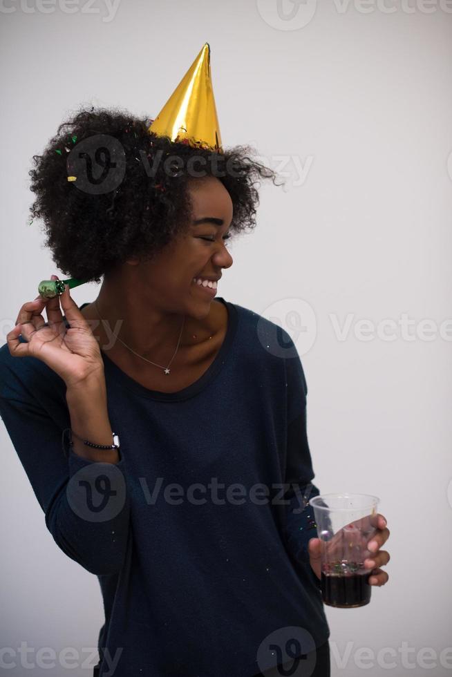 schwarze frau mit partyhut, die in pfeife bläst foto