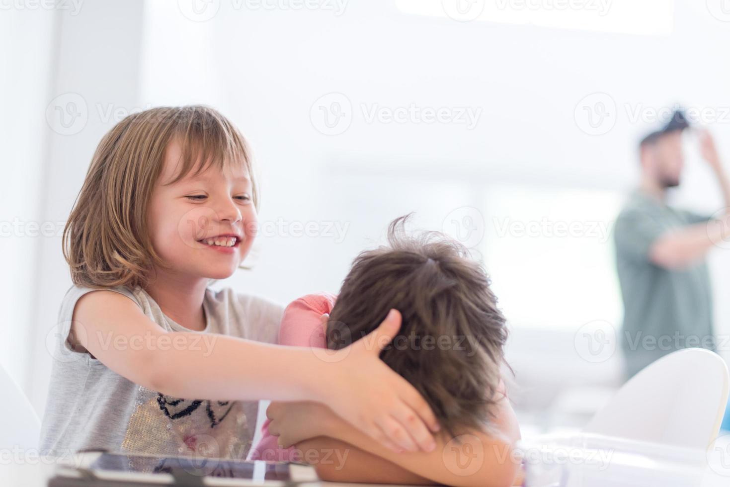 süßer kleiner bruder und schwester, die sich zu hause amüsieren foto