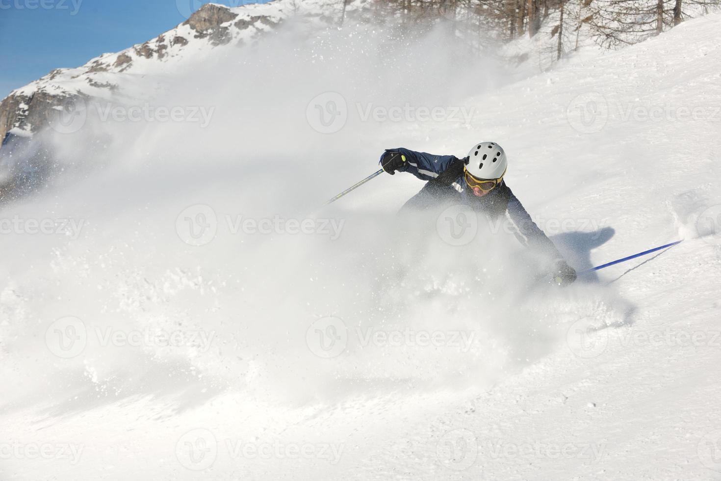 Skifahren auf Neuschnee in der Wintersaison am schönen sonnigen Tag foto