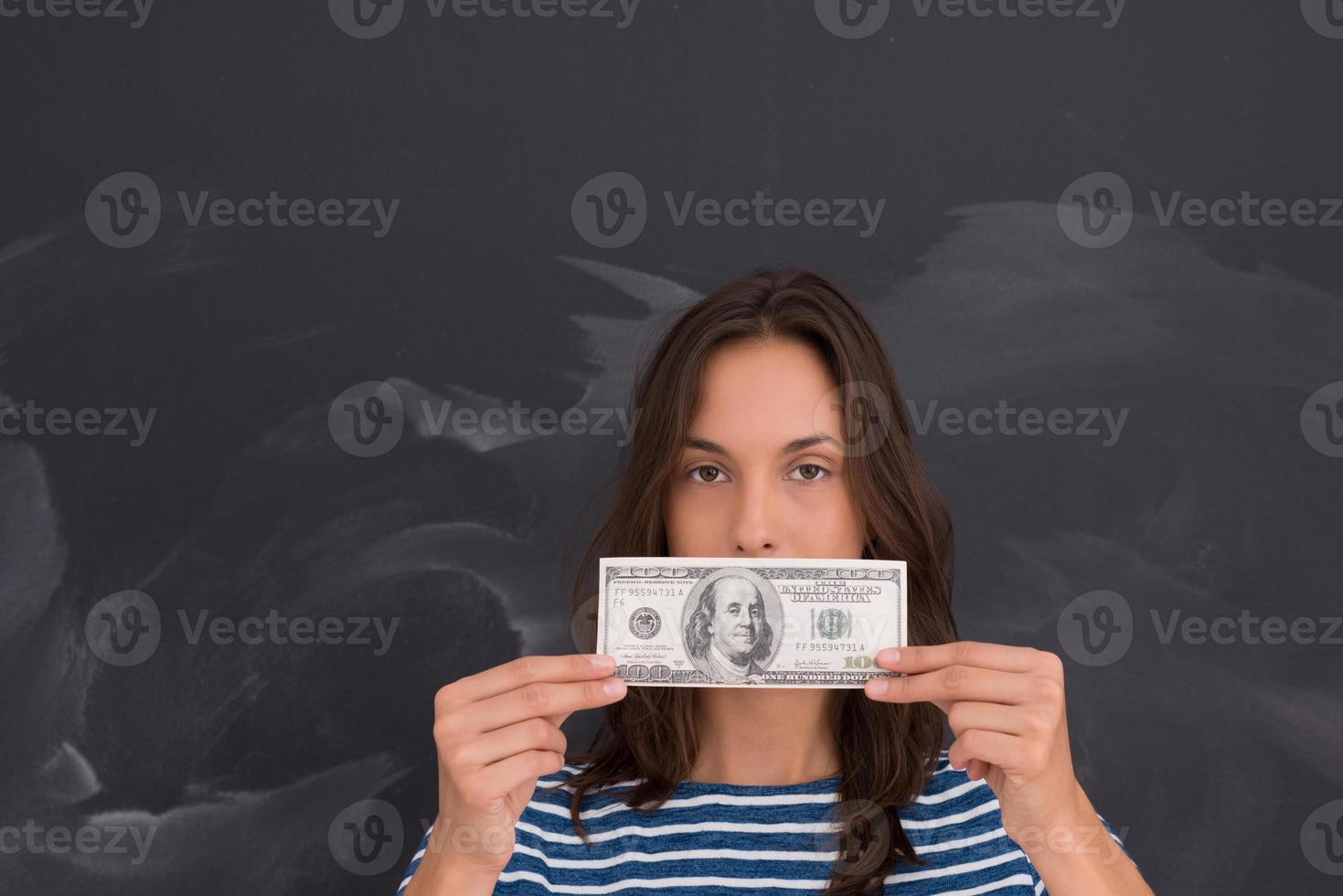 Frau hält eine Banknote vor Kreidezeichenbrett foto