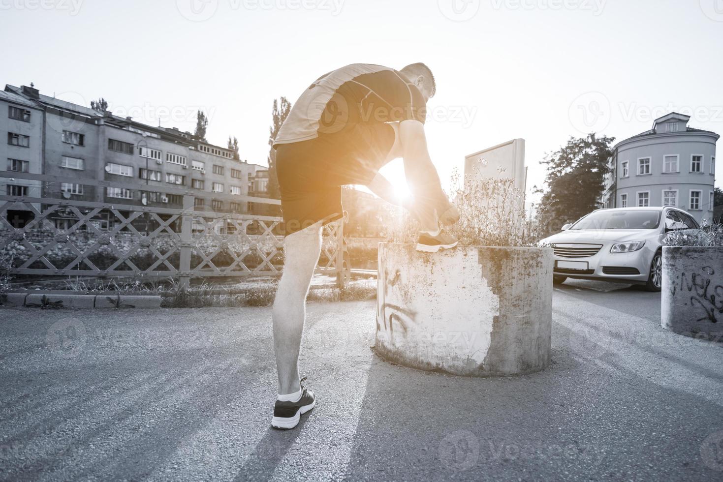 Mann bindet Laufschuhe Schnürsenkel foto