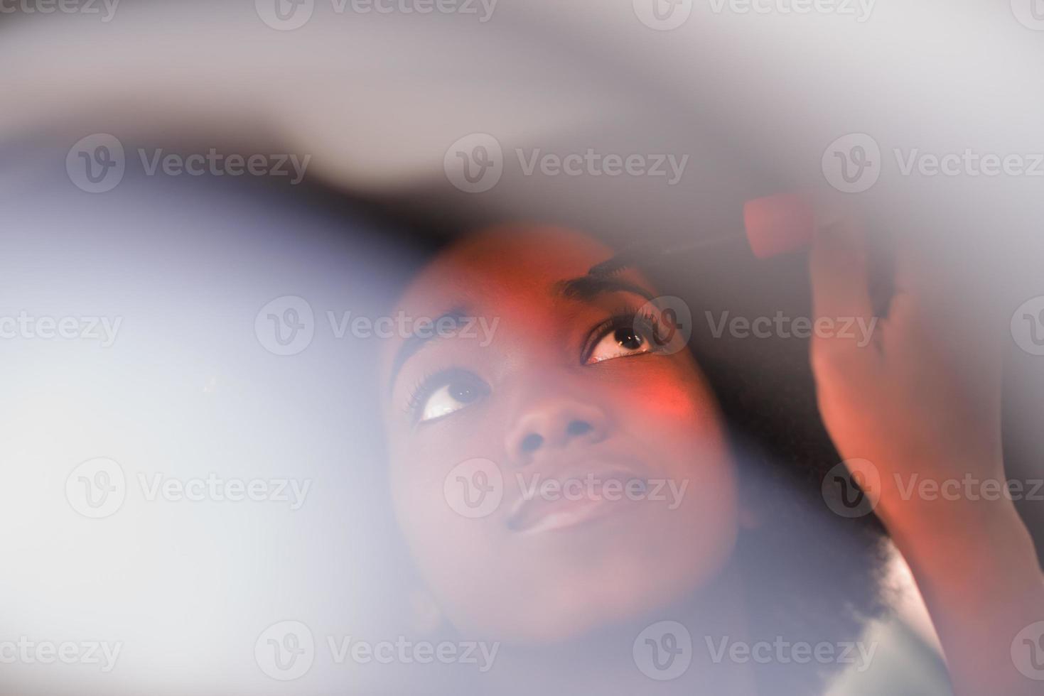 Make-up einer jungen afroamerikanischen Frau im Auto foto