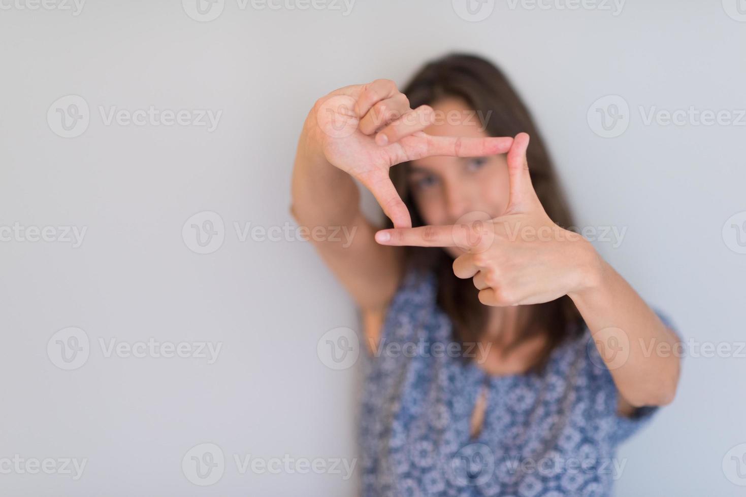 frau, die rahmenhandgeste zeigt foto