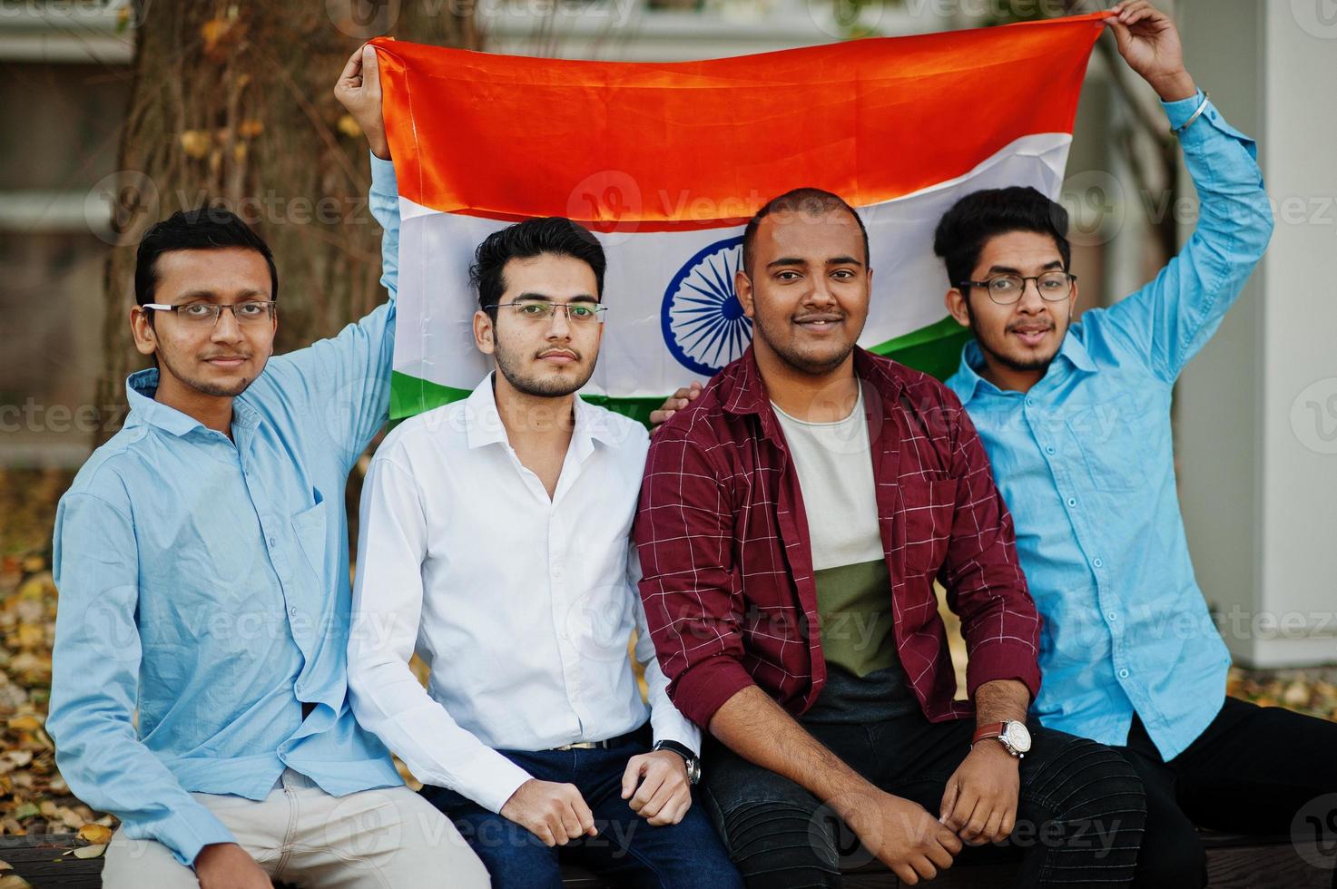 Gruppe von vier südasiatischen indischen Männchen mit Indien-Flagge. foto