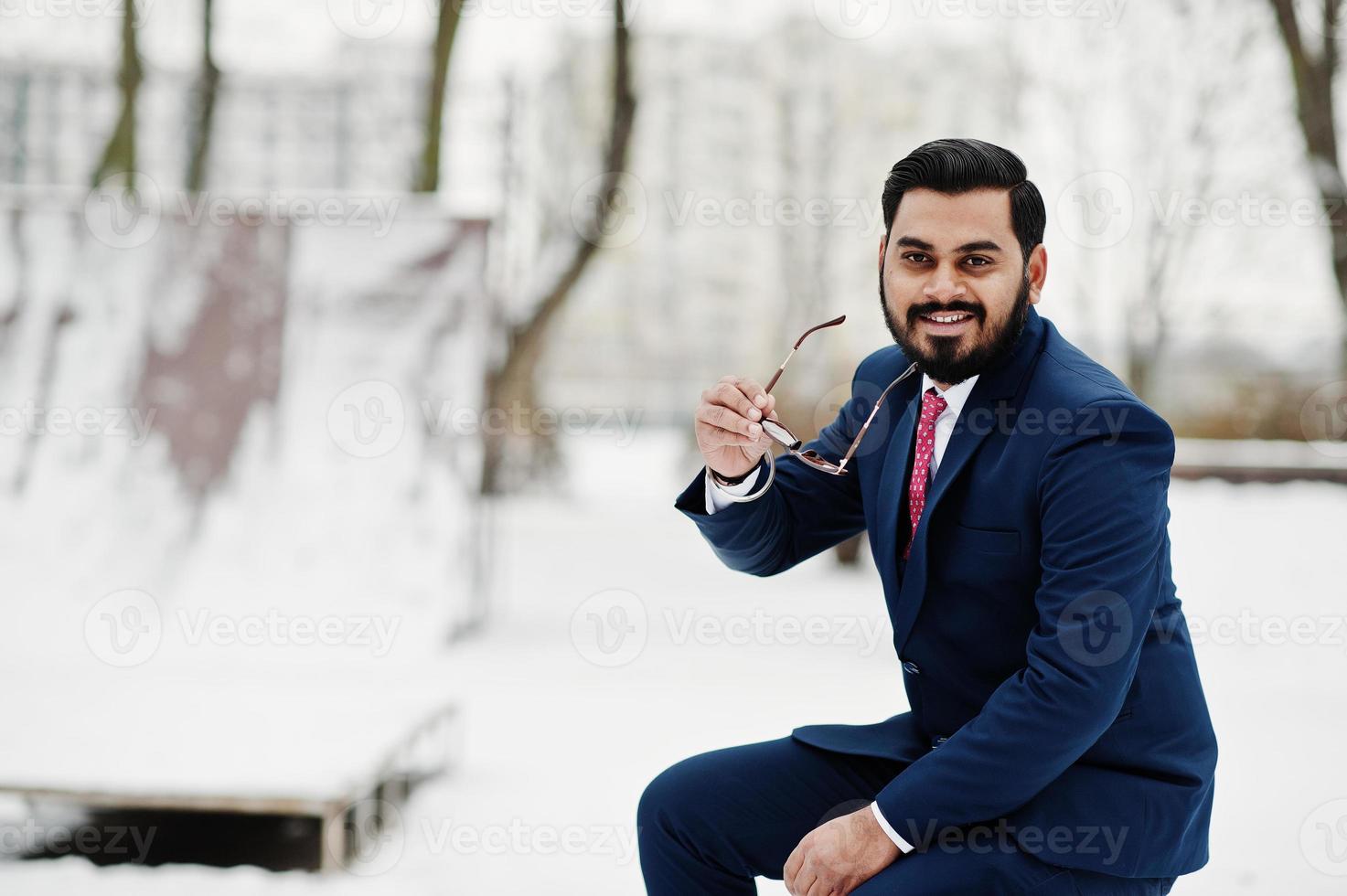 Stilvoller indischer Bart Geschäftsmann in Anzug und Sonnenbrille posierte am Wintertag im Freien. foto