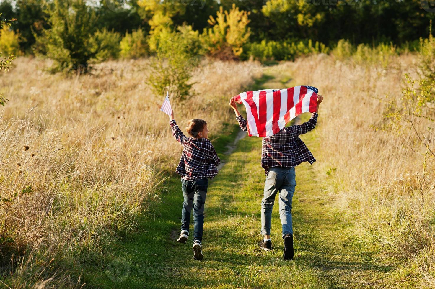 zwei brüder laufen mit usa-flagge. amerika urlaub. stolz, Kinder des Landes zu sein. foto