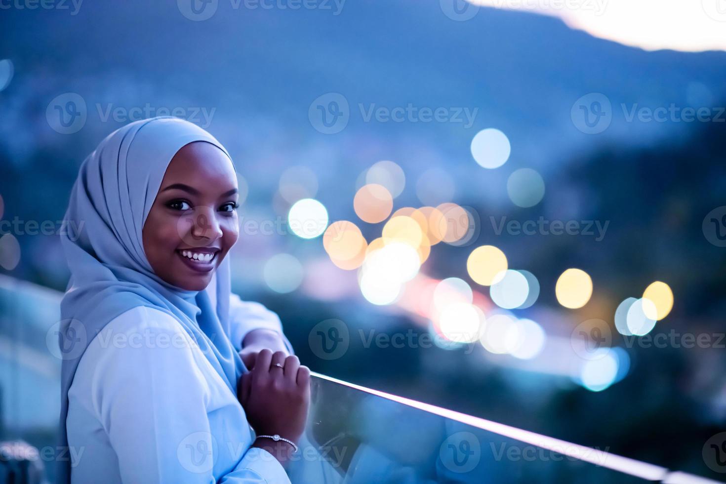 afrikanische moderne muslimische frau in der nacht auf dem balkon foto